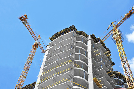 40545183 - crane and building construction site against blue sky