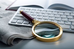 62232853 - magnifier and newspaper on the keyboard closeup